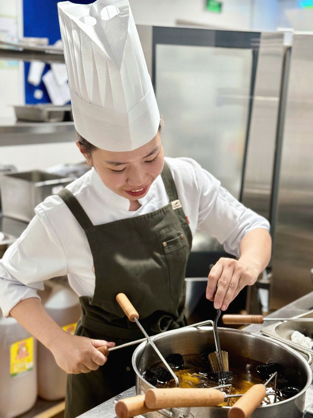 Nữ đầu bếp đội mũ bếp cao đang nấu
